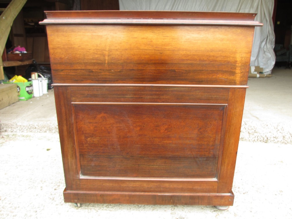 A Victorian rosewood davenport secretaire desk featuring an open black leather-lined writing slope, an upper gallery with drawers and pigeonholes, side drawers, and carved cabriole supports. View XII