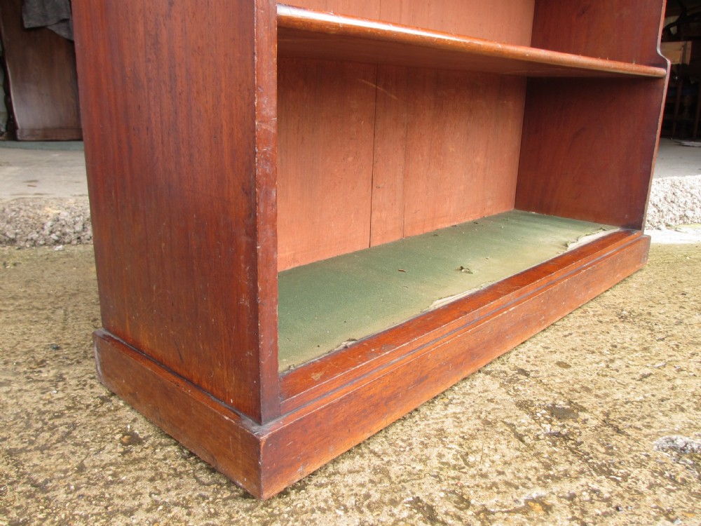 A tall 19th-century mahogany waterfall bookcase featuring six graduating open shelves with green fabric lining and a shaped gallery top. View II