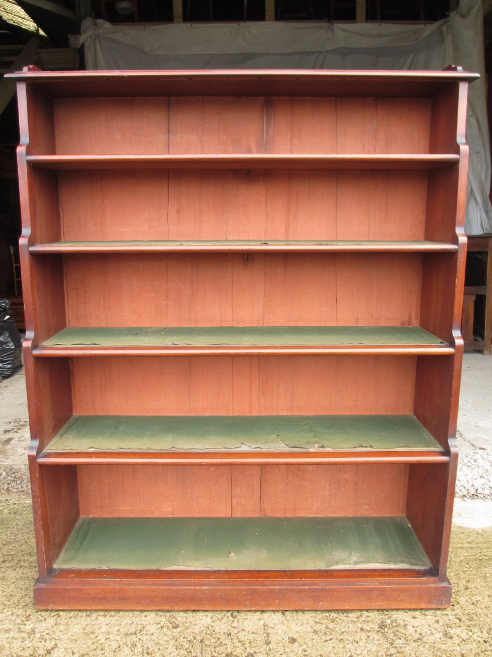 A tall 19th-century mahogany waterfall bookcase featuring six graduating open shelves with green fabric lining and a shaped gallery top. View III