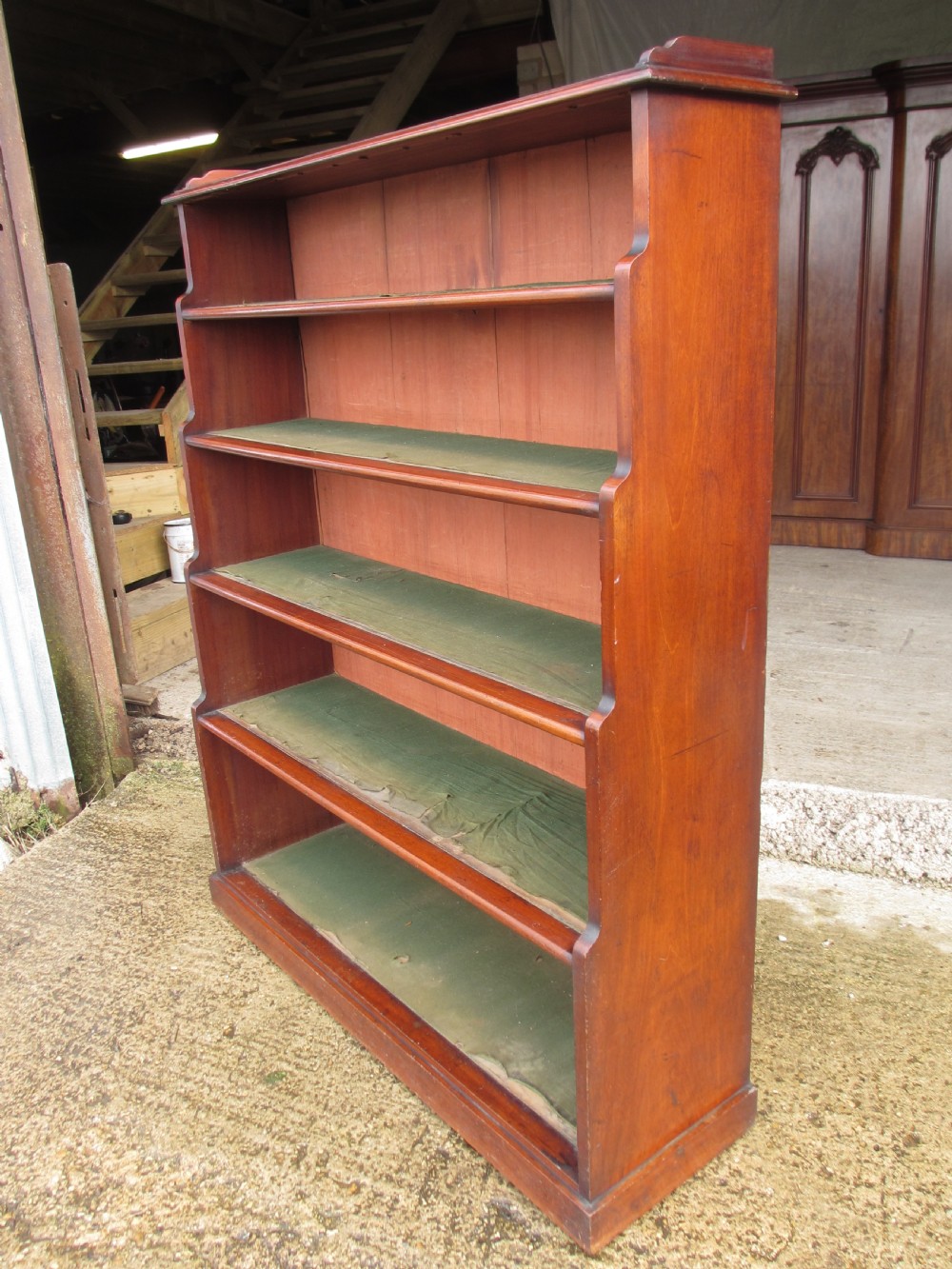 A tall 19th-century mahogany waterfall bookcase featuring six graduating open shelves with green fabric lining and a shaped gallery top. View IV