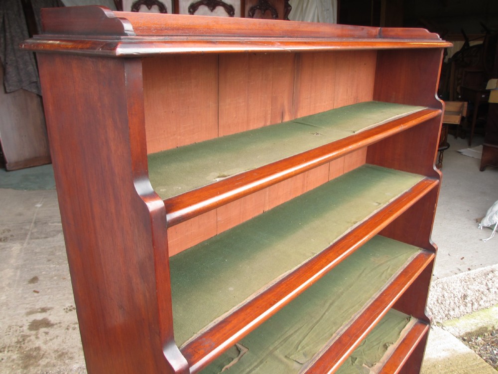 A tall 19th-century mahogany waterfall bookcase featuring six graduating open shelves with green fabric lining and a shaped gallery top. View VI