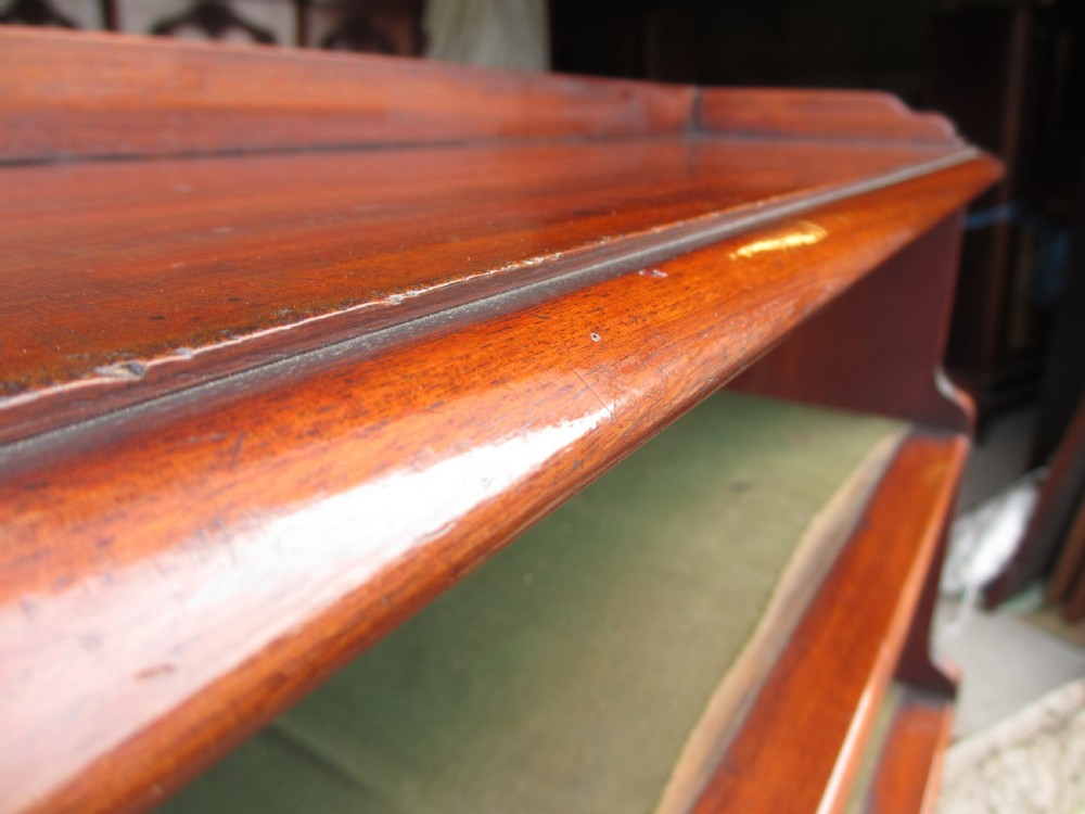 A tall 19th-century mahogany waterfall bookcase featuring six graduating open shelves with green fabric lining and a shaped gallery top. View VII