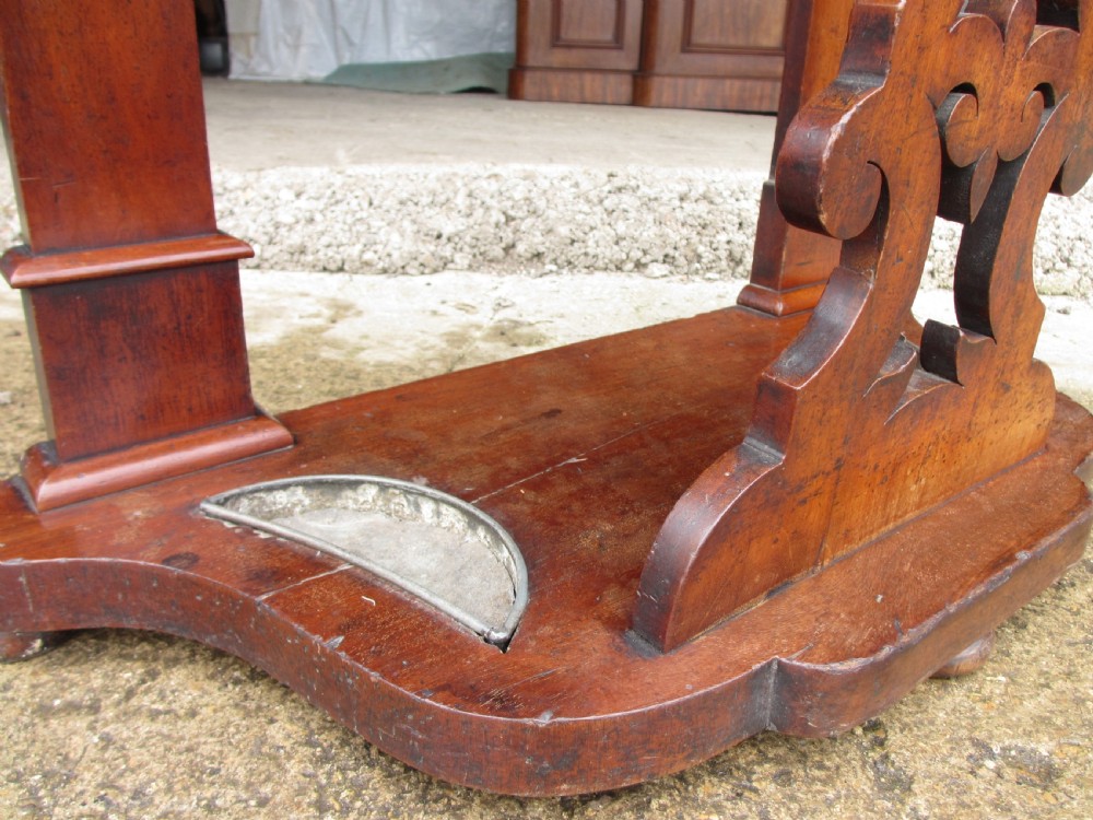 A tall Victorian mahogany hall stand featuring a central mirror, carved top crest, coat pegs, a white marble shelf, and lower umbrella drip trays. View V