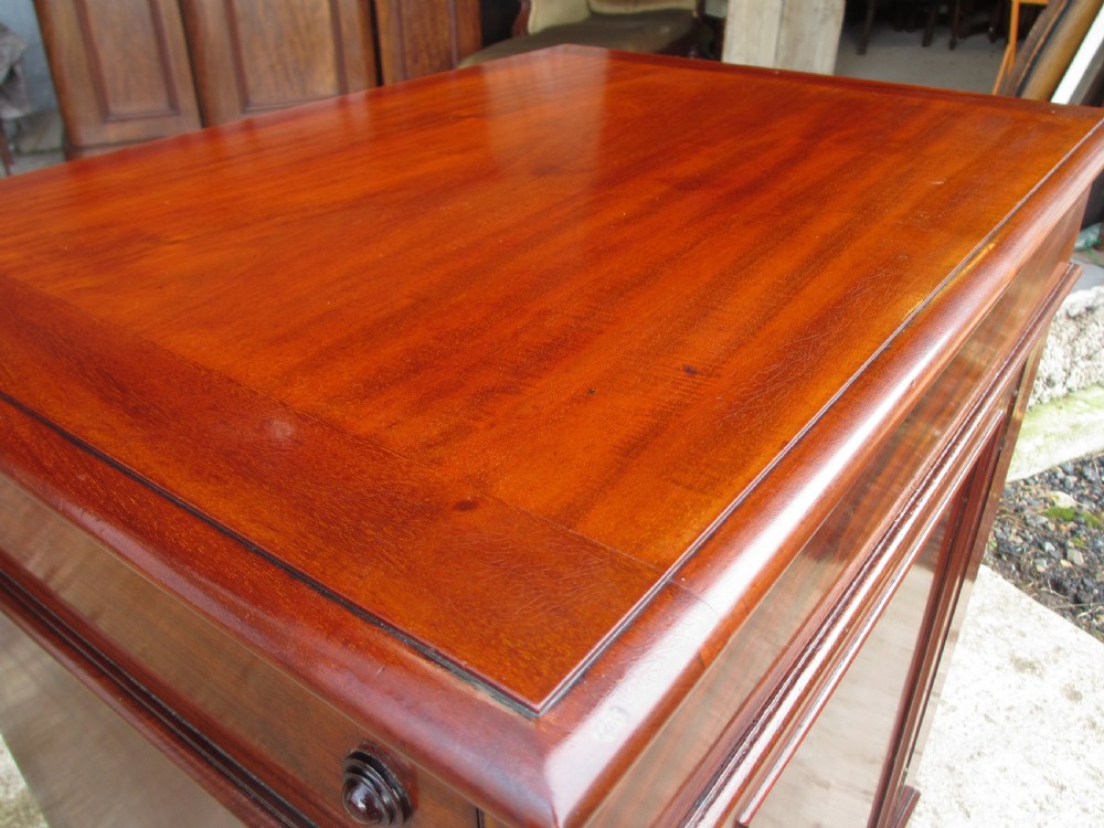 A Victorian flame mahogany washstand cupboard with a single panelled door, wooden knob handle, and plinth base. View III