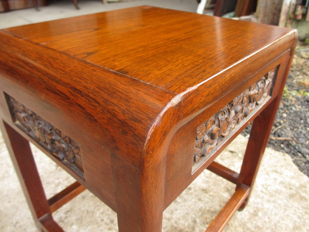 A set of four graduating rosewood side tables nested together, featuring relief-carved lotus friezes and straight legs. View VI