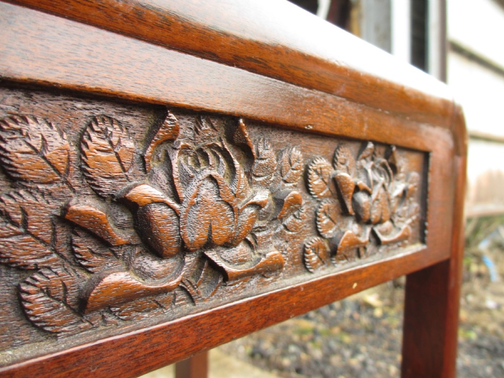 A set of four graduating rosewood side tables nested together, featuring relief-carved lotus friezes and straight legs. View VIII
