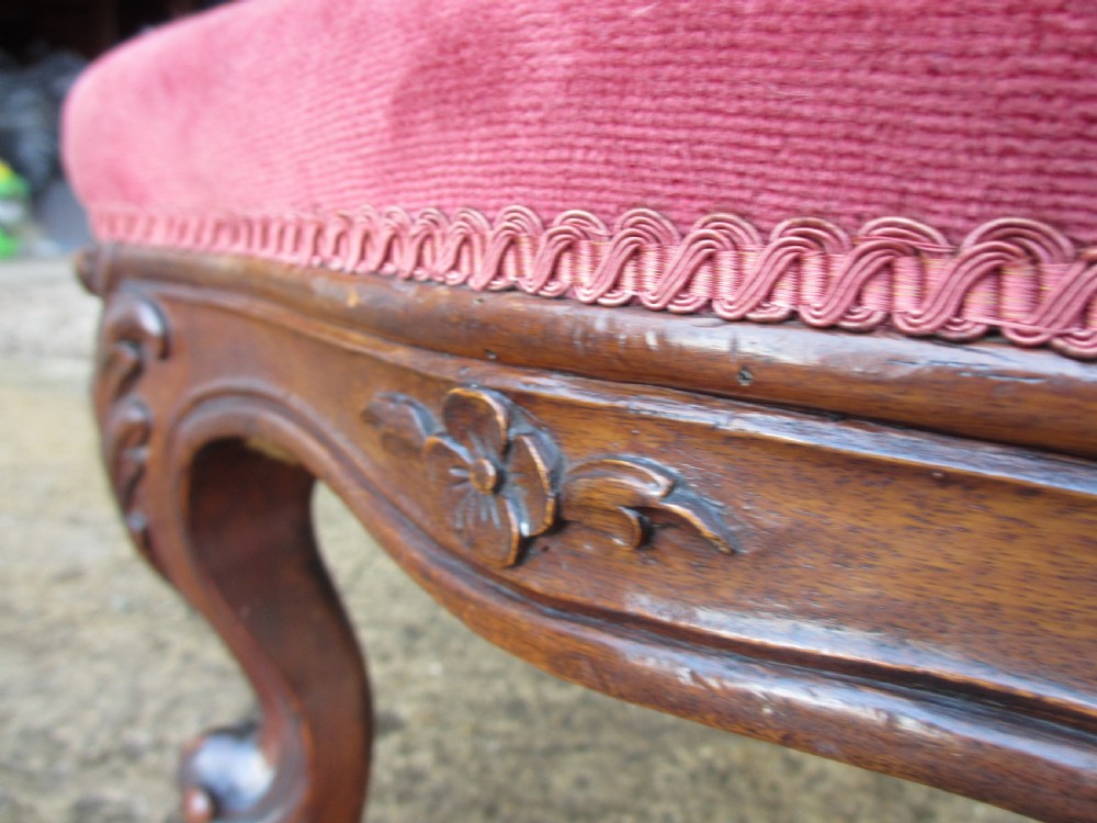 A Victorian carved mahogany prie-dieu chair featuring a tall padded backrest and low seat upholstered in crimson velvet with carved cabriole front legs. View VIII