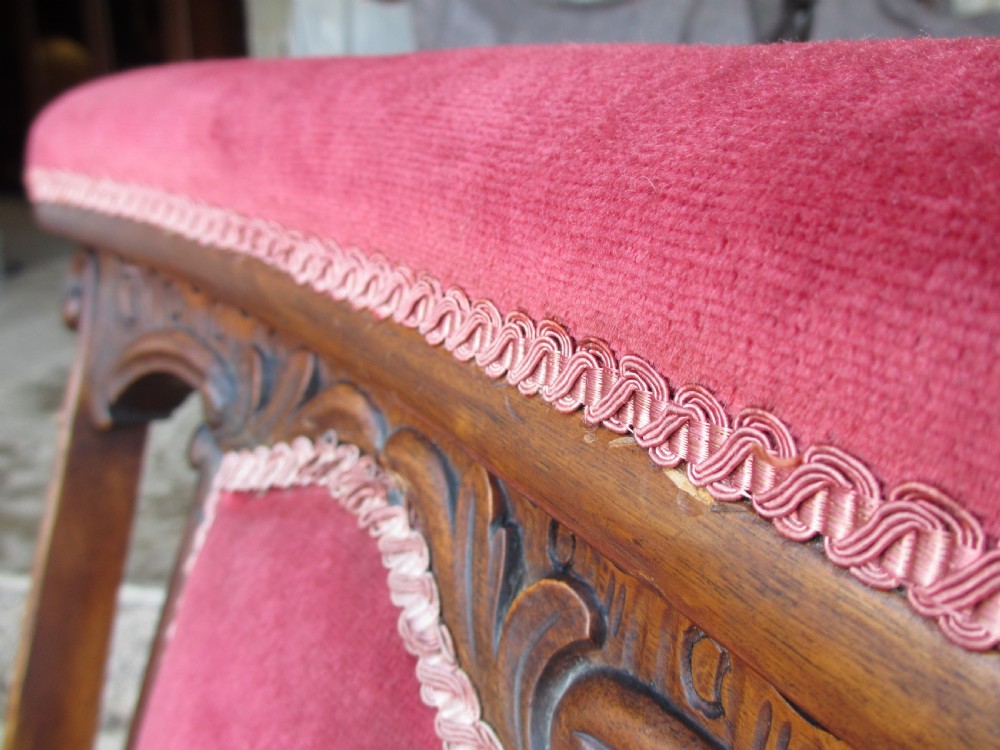 A Victorian carved mahogany prie-dieu chair featuring a tall padded backrest and low seat upholstered in crimson velvet with carved cabriole front legs. View XII