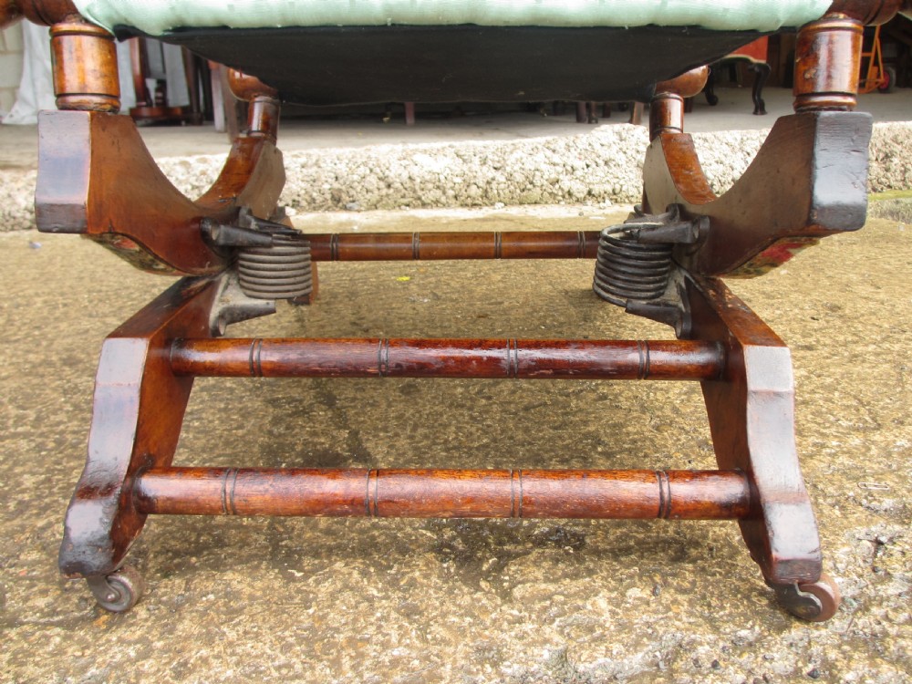 A 19th-century American platform rocking chair crafted from turned beechwood with pale green fabric upholstery on a stationary spring base. View VIII