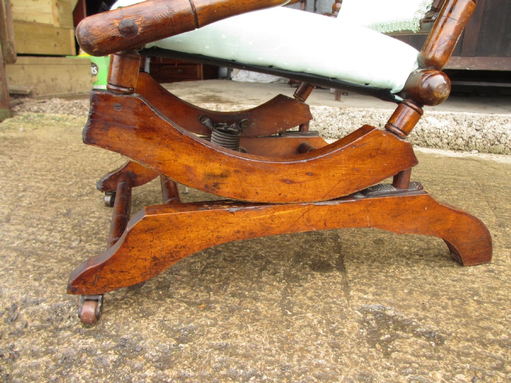 A 19th-century American platform rocking chair crafted from turned beechwood with pale green fabric upholstery on a stationary spring base. View IX