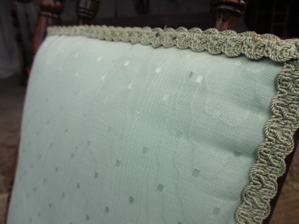 A 19th-century American platform rocking chair crafted from turned beechwood with pale green fabric upholstery on a stationary spring base. View XI