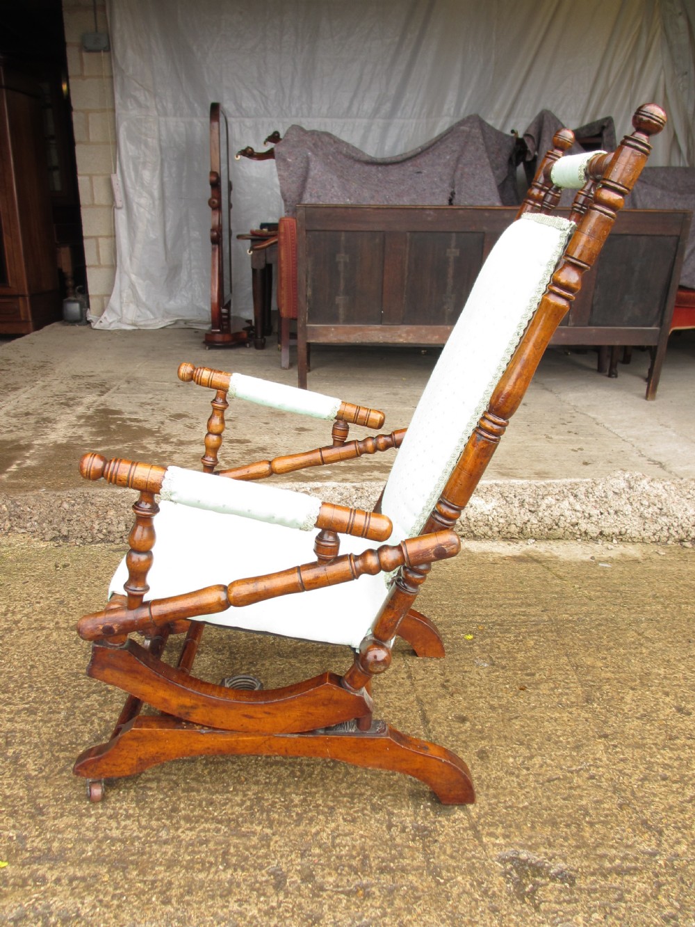 A 19th-century American platform rocking chair crafted from turned beechwood with pale green fabric upholstery on a stationary spring base. View XIV