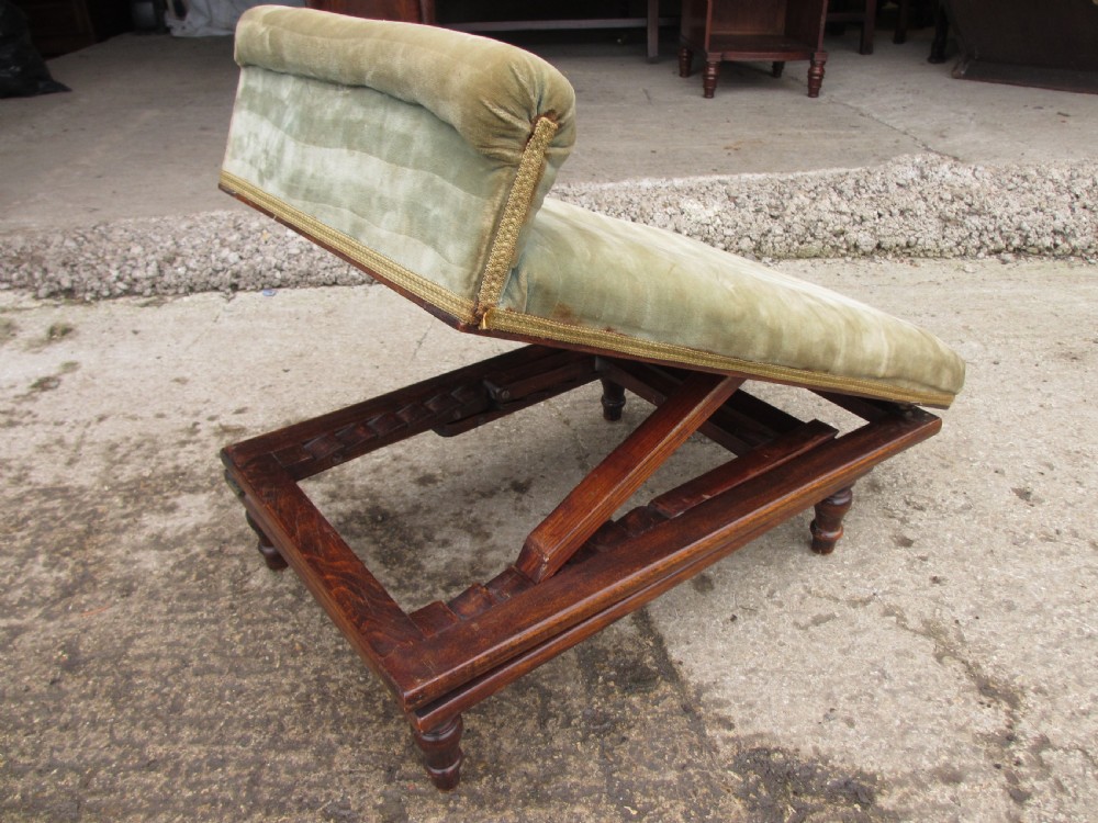A nineteenth-century beechwood gout stool with an adjustable angled top upholstered in light green striped velvet fabric set upon a dark timber ratchet frame. View VI
