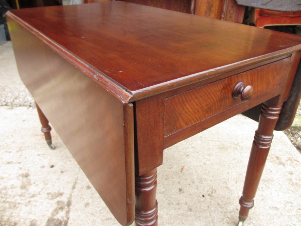 Victorian mahogany Pembroke table with two hinged drop leaves, an end drawer with wooden knobs, and turned legs fitted with brass castors. View IV
