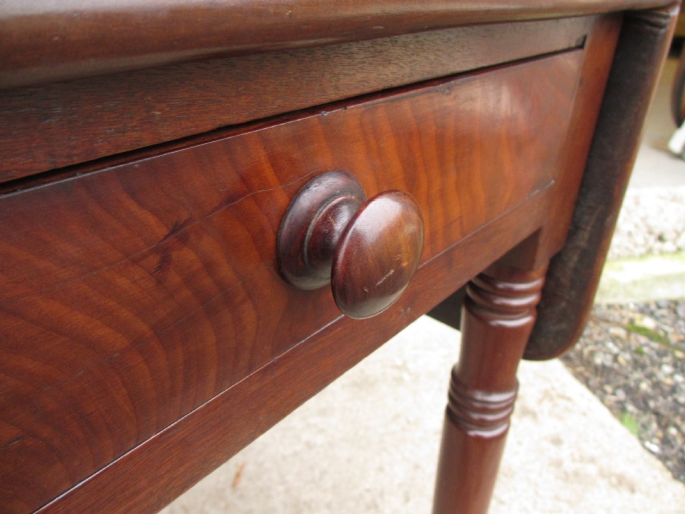 Victorian mahogany Pembroke table with two hinged drop leaves, an end drawer with wooden knobs, and turned legs fitted with brass castors. View V