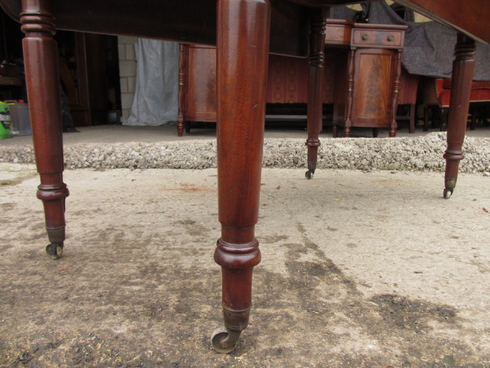 Victorian mahogany Pembroke table with two hinged drop leaves, an end drawer with wooden knobs, and turned legs fitted with brass castors. View VI