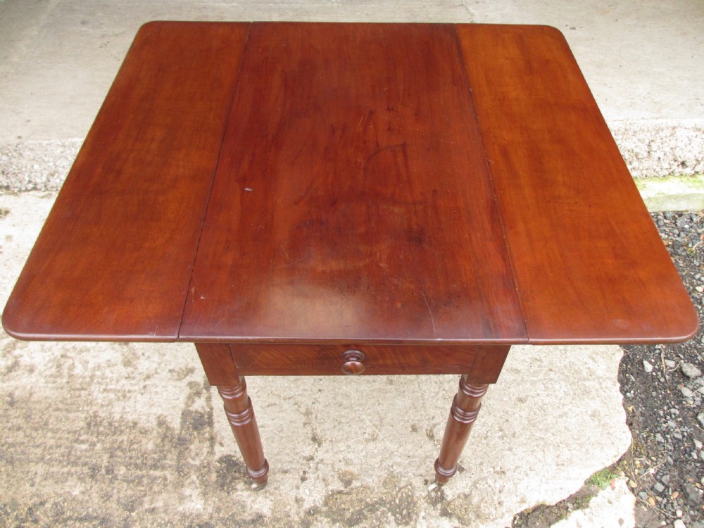 Victorian mahogany Pembroke table with two hinged drop leaves, an end drawer with wooden knobs, and turned legs fitted with brass castors. View IX