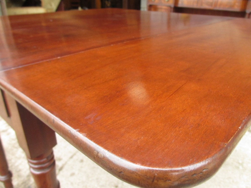 Victorian mahogany Pembroke table with two hinged drop leaves, an end drawer with wooden knobs, and turned legs fitted with brass castors. View X