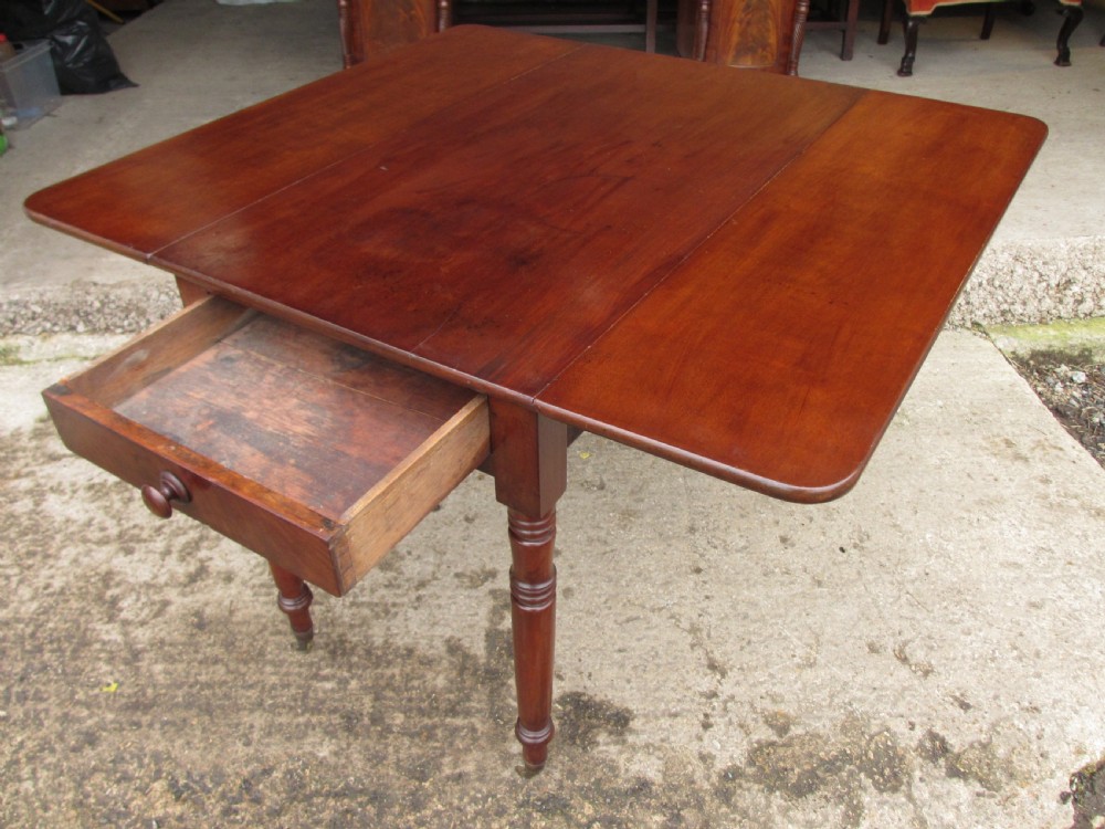 Victorian mahogany Pembroke table with two hinged drop leaves, an end drawer with wooden knobs, and turned legs fitted with brass castors. View XI