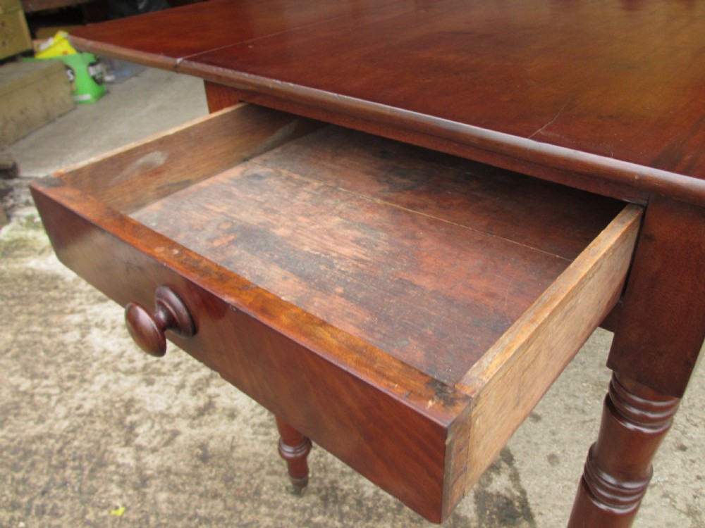 Victorian mahogany Pembroke table with two hinged drop leaves, an end drawer with wooden knobs, and turned legs fitted with brass castors. View XII