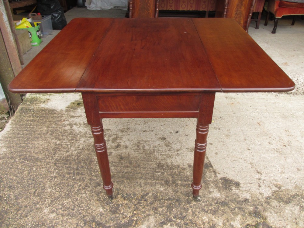 Victorian mahogany Pembroke table with two hinged drop leaves, an end drawer with wooden knobs, and turned legs fitted with brass castors. View XIV