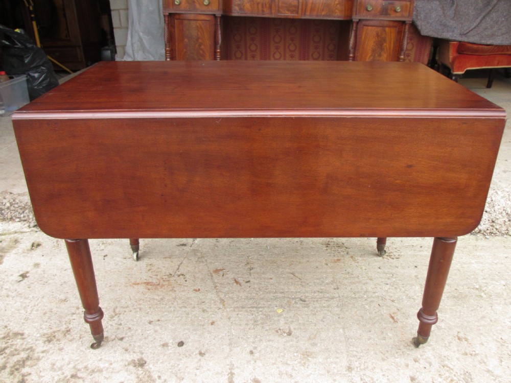 Victorian mahogany Pembroke table with two hinged drop leaves, an end drawer with wooden knobs, and turned legs fitted with brass castors. View XV