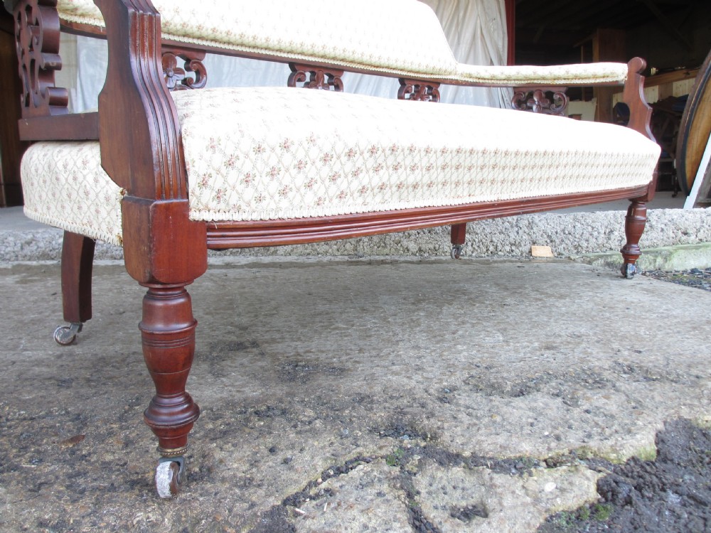 A five-piece antique mahogany parlour suite including a settee, two tub armchairs, and two side chairs with cream patterned upholstery and carved details. View IV