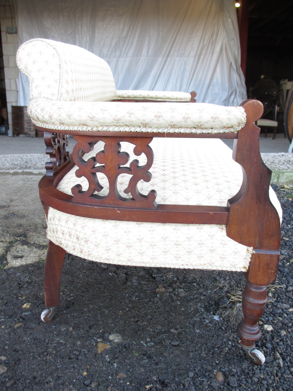 A five-piece antique mahogany parlour suite including a settee, two tub armchairs, and two side chairs with cream patterned upholstery and carved details. View V