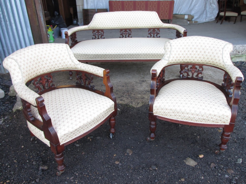 A five-piece antique mahogany parlour suite including a settee, two tub armchairs, and two side chairs with cream patterned upholstery and carved details. View VIII