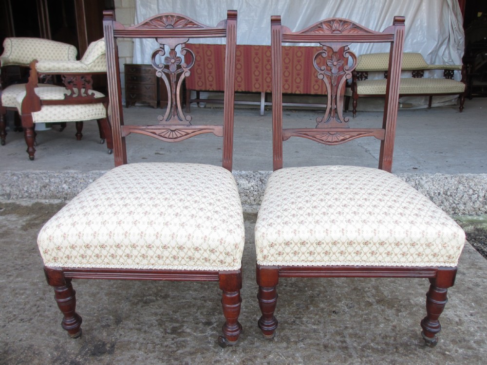A five-piece antique mahogany parlour suite including a settee, two tub armchairs, and two side chairs with cream patterned upholstery and carved details. View XVIII