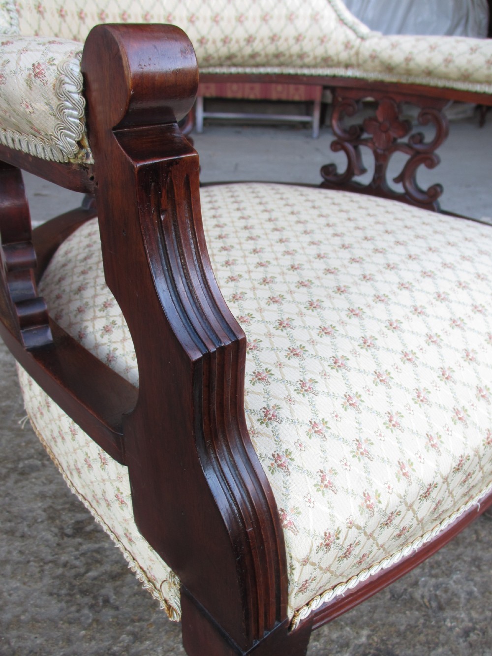 A pair of antique mahogany tub armchairs featuring cream patterned fabric upholstery, openwork carved back splats, and turned front legs on castors. View VII