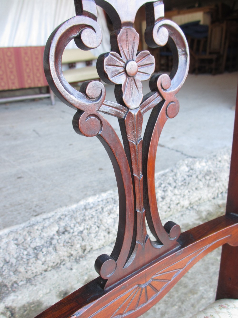 A pair of Edwardian mahogany nursing chairs featuring low seats, pattern-upholstered cushions, carved backs with decorative central splats, and turned front legs with castors. View VIII