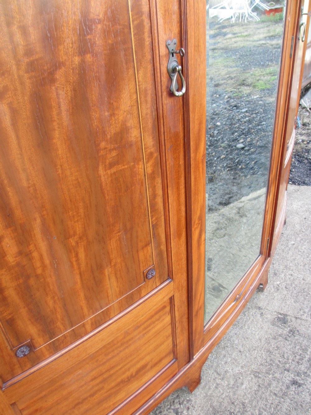 A Victorian bow-fronted mahogany triple wardrobe featuring a central full-length mirror door flanked by panelled flame mahogany doors. View XIII