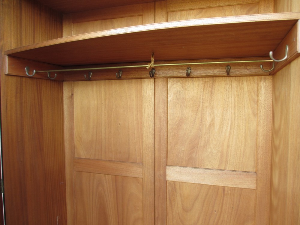 A Victorian bow-fronted mahogany triple wardrobe featuring a central full-length mirror door flanked by panelled flame mahogany doors. View XVI