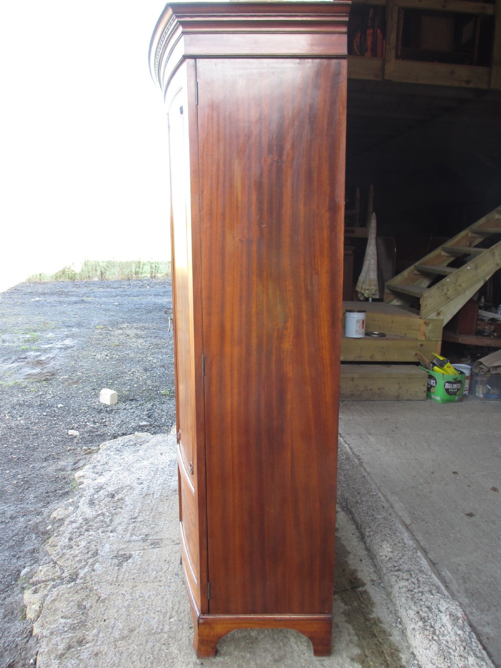 A Victorian bow-fronted mahogany triple wardrobe featuring a central full-length mirror door flanked by panelled flame mahogany doors. View XVIII