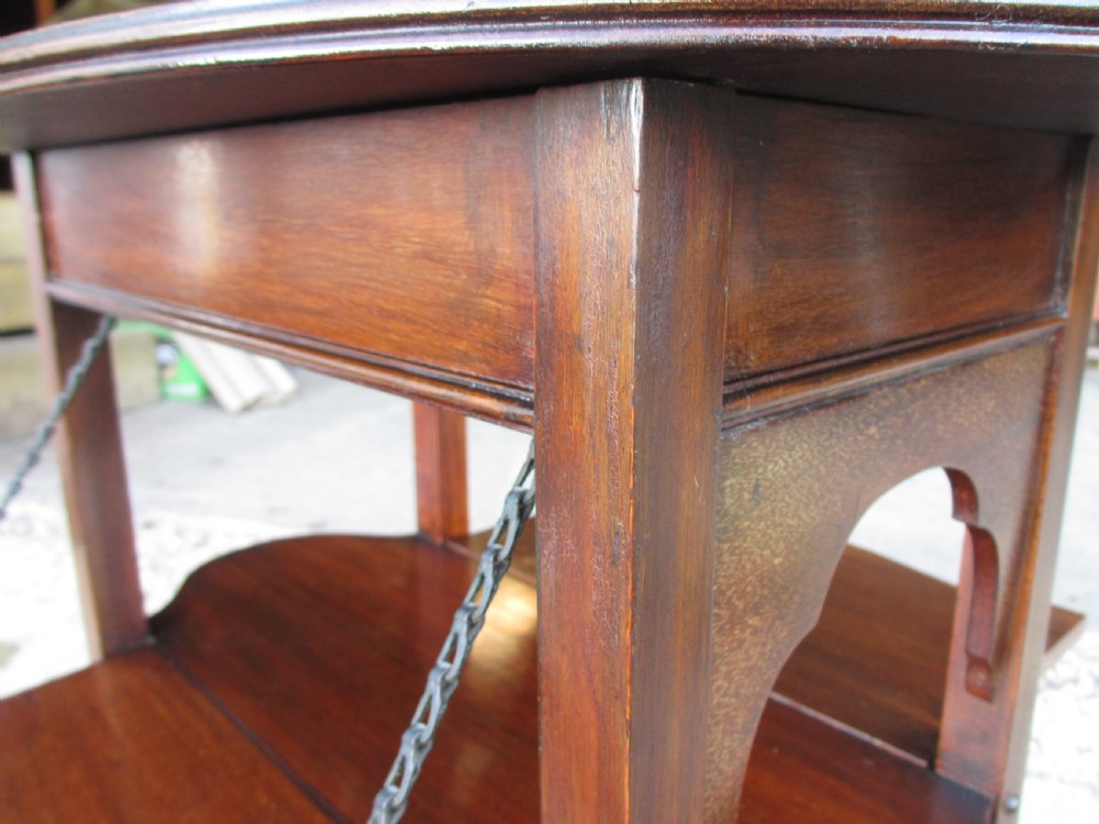 Victorian mahogany oval occasional table with lower shelf and fold-down side leaves held by metal chains. View V