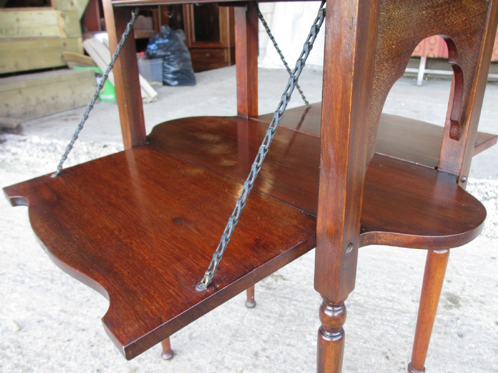 Victorian mahogany oval occasional table with lower shelf and fold-down side leaves held by metal chains. View VI