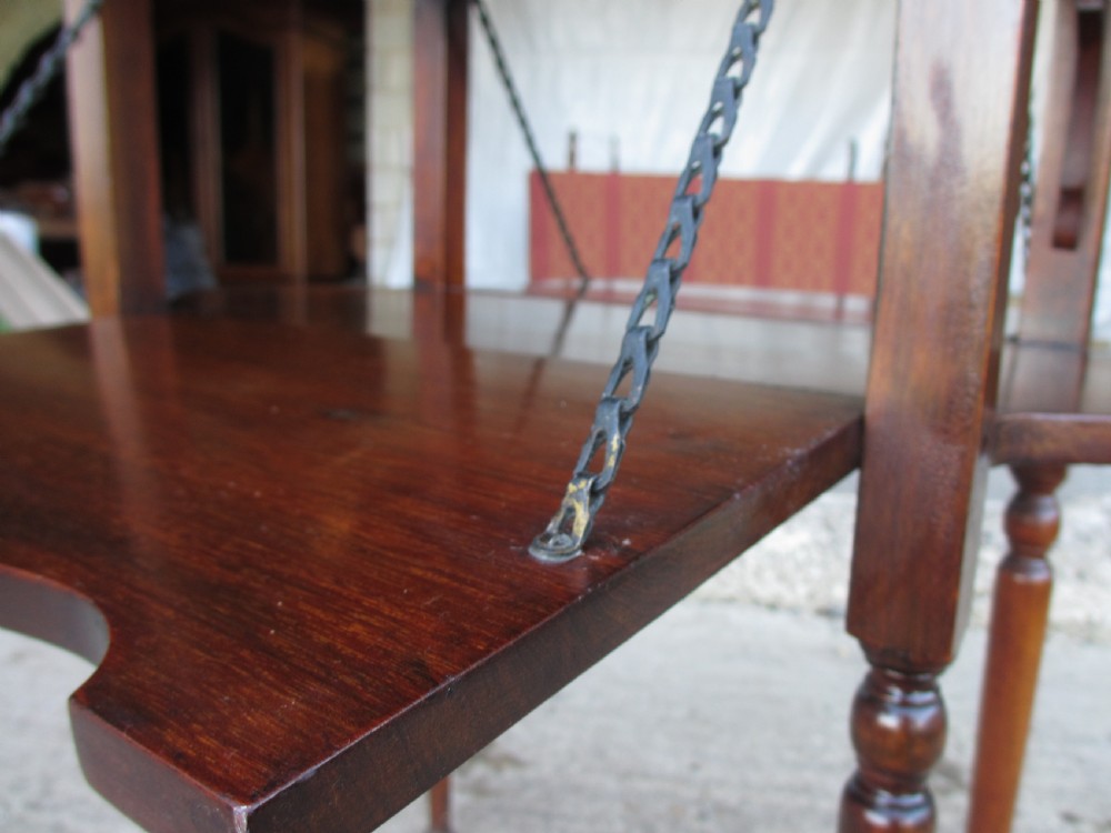 Victorian mahogany oval occasional table with lower shelf and fold-down side leaves held by metal chains. View IX
