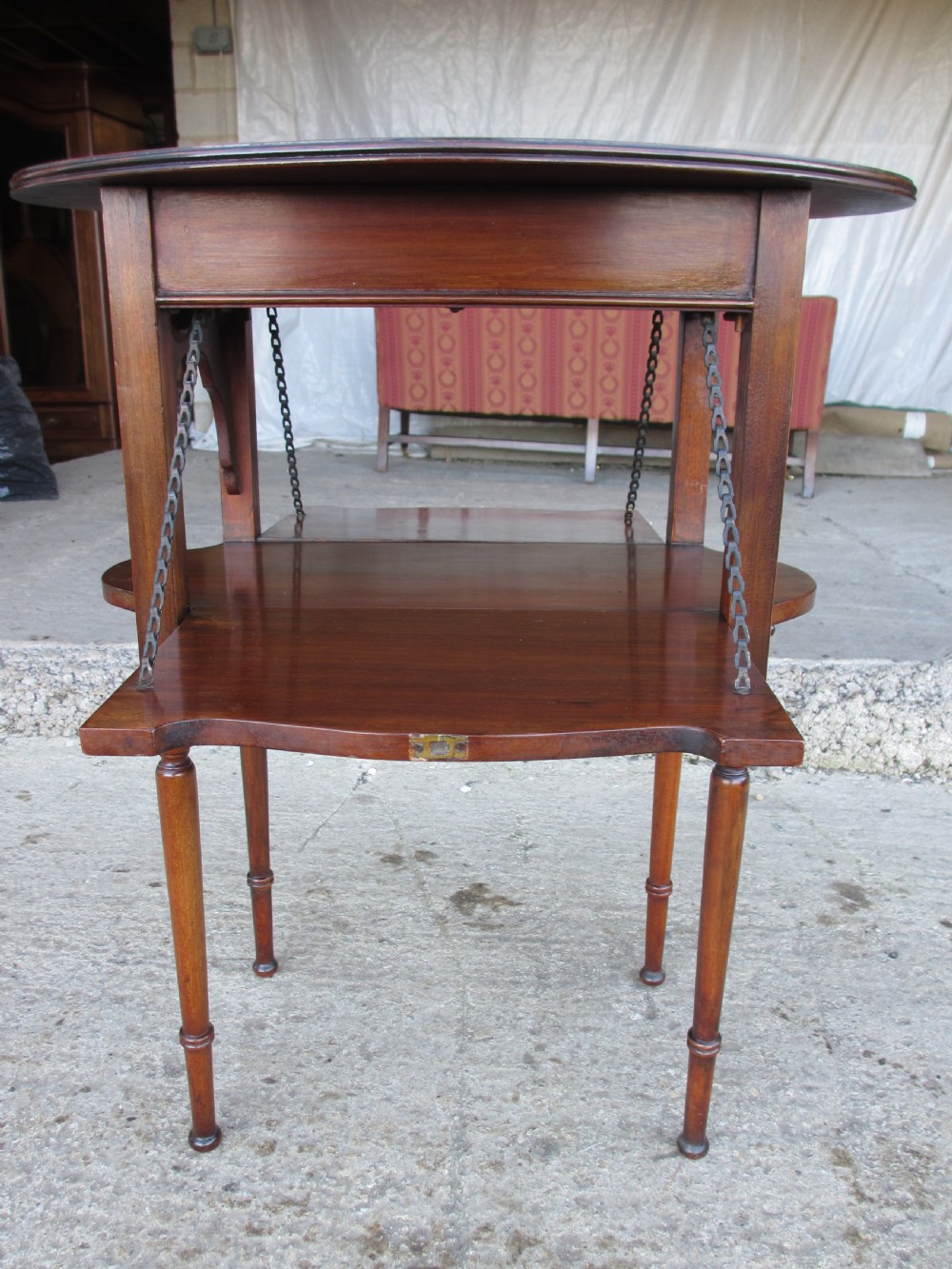 Victorian mahogany oval occasional table with lower shelf and fold-down side leaves held by metal chains. View XII