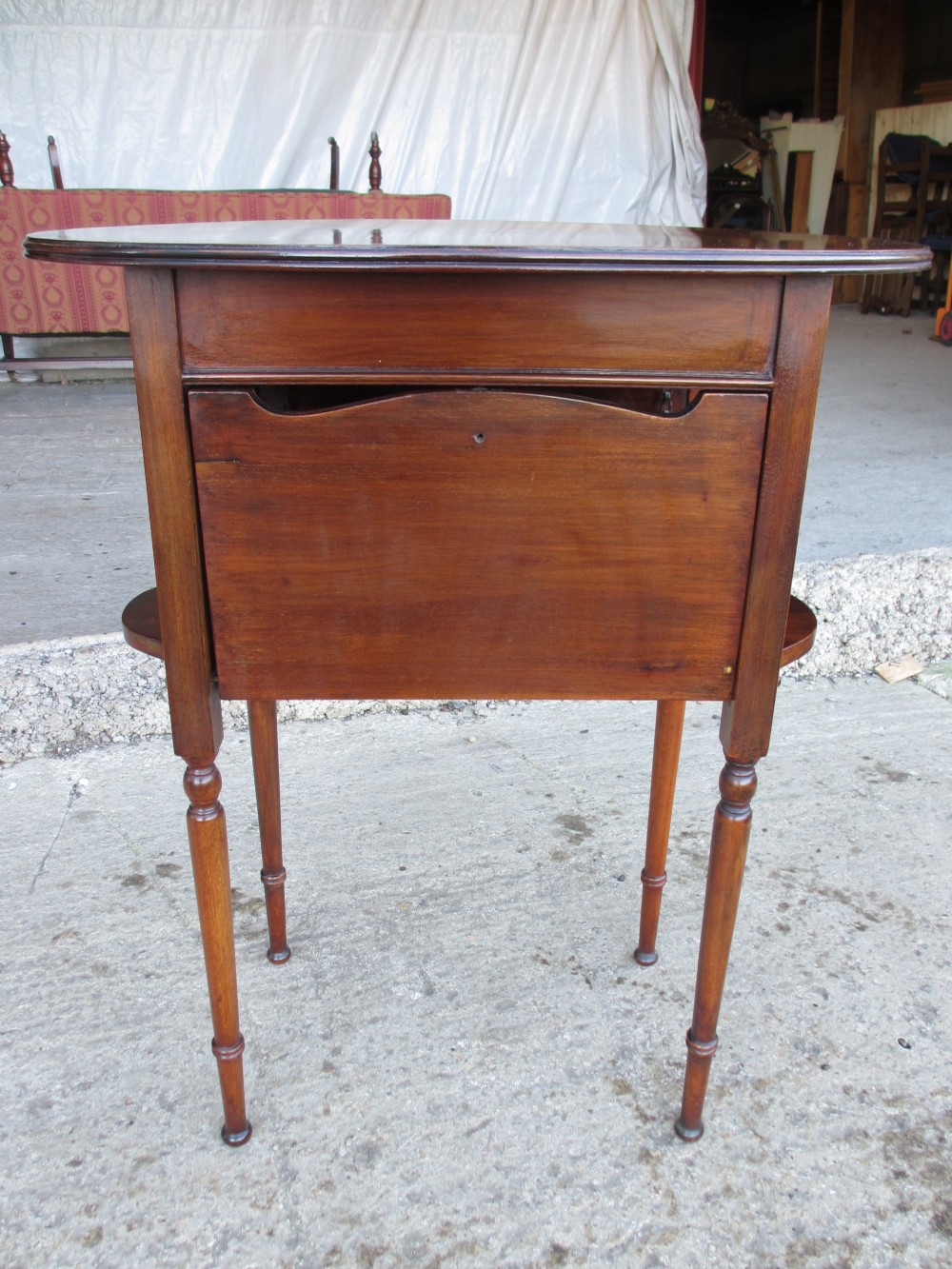 Victorian mahogany oval occasional table with lower shelf and fold-down side leaves held by metal chains. View XIII