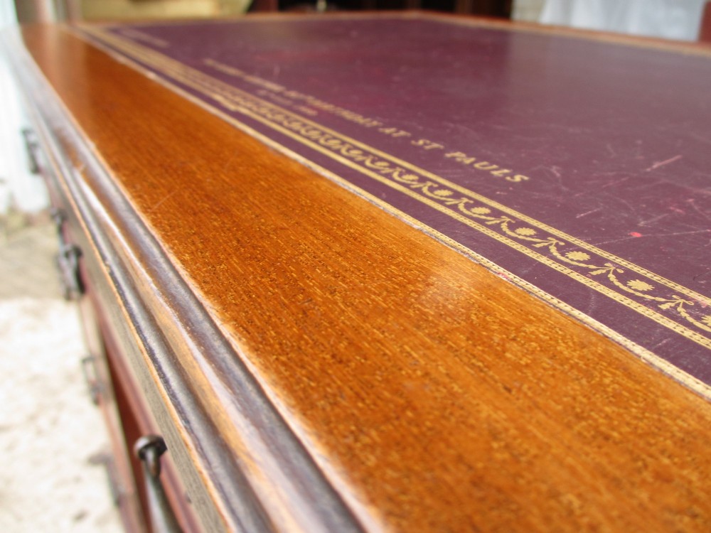A Victorian walnut pedestal desk featuring nine drawers with brass drop handles and a maroon tooled leather inset writing surface. View IX