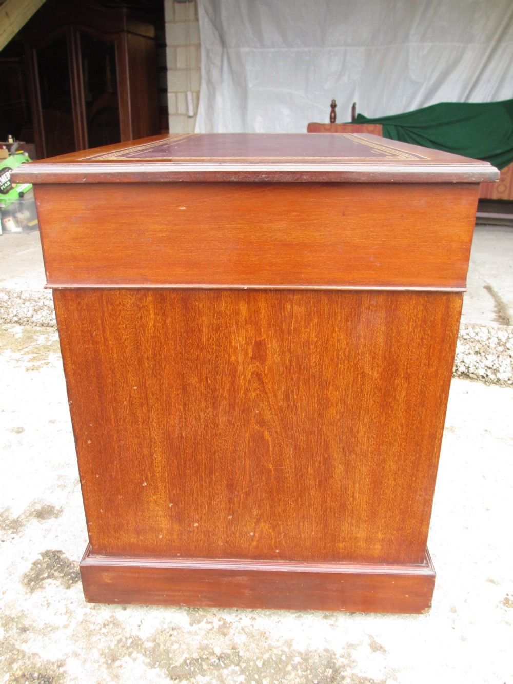 A Victorian walnut pedestal desk featuring nine drawers with brass drop handles and a maroon tooled leather inset writing surface. View XIII