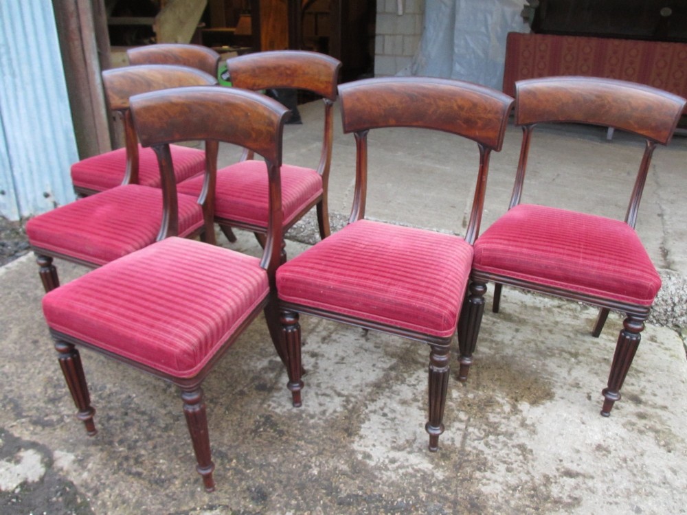 A set of six William IV mahogany dining chairs featuring curved top rails with flame mahogany veneer, reeded turned front legs, and red striped upholstered seats. View II