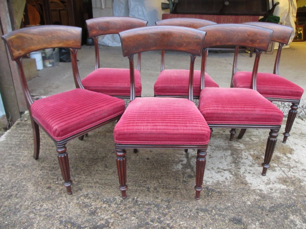 A set of six William IV mahogany dining chairs featuring curved top rails with flame mahogany veneer, reeded turned front legs, and red striped upholstered seats. View III