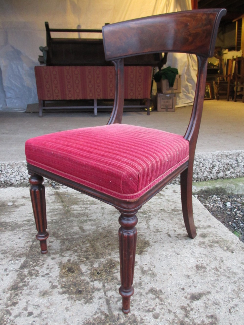 A set of six William IV mahogany dining chairs featuring curved top rails with flame mahogany veneer, reeded turned front legs, and red striped upholstered seats. View VI