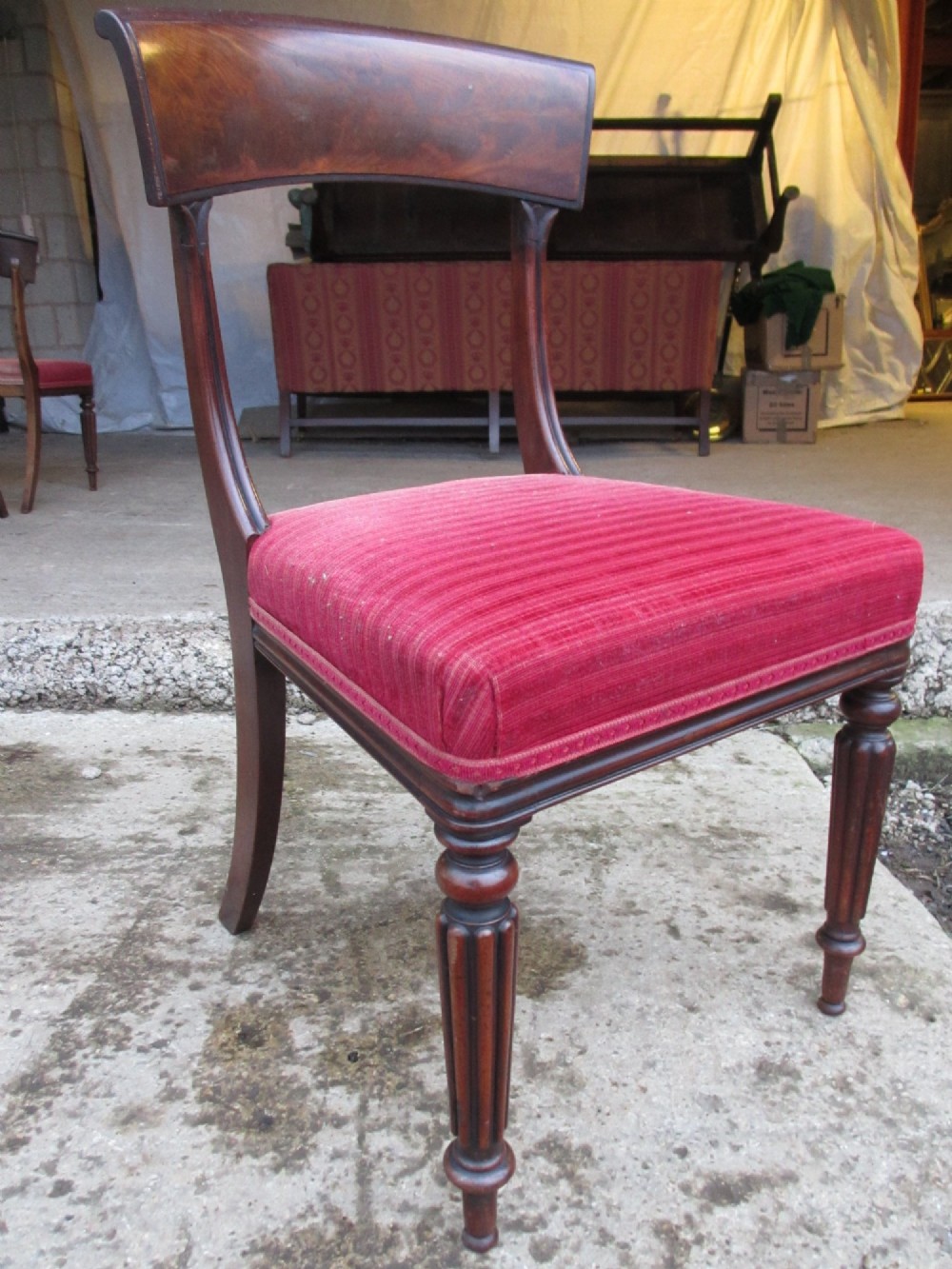 A set of six William IV mahogany dining chairs featuring curved top rails with flame mahogany veneer, reeded turned front legs, and red striped upholstered seats. View VII