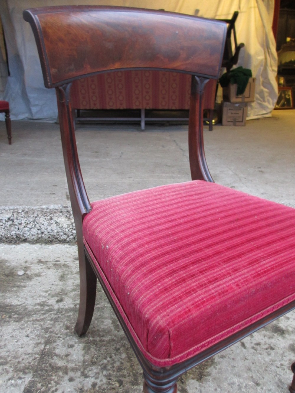 A set of six William IV mahogany dining chairs featuring curved top rails with flame mahogany veneer, reeded turned front legs, and red striped upholstered seats. View VIII