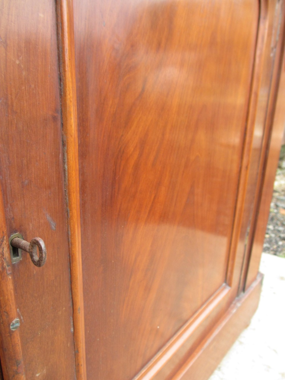 A two-piece Victorian mahogany bookcase featuring an upper section with two glazed doors and carved corbels over a lower cabinet with flame mahogany panelled doors. View VIII