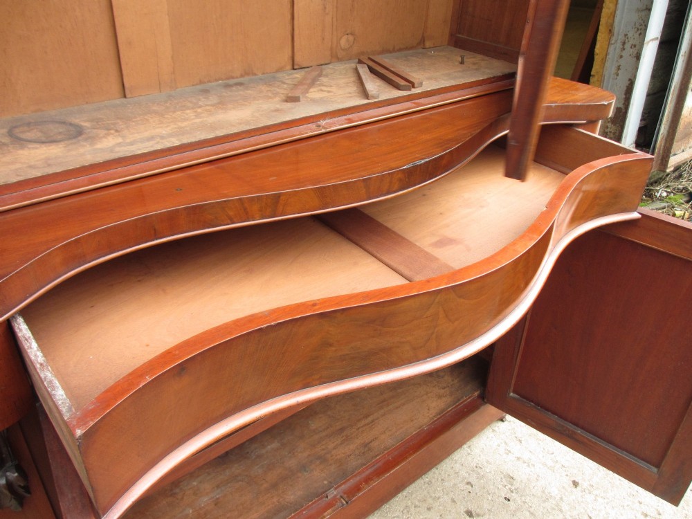 A two-piece Victorian mahogany bookcase featuring an upper section with two glazed doors and carved corbels over a lower cabinet with flame mahogany panelled doors. View XIII