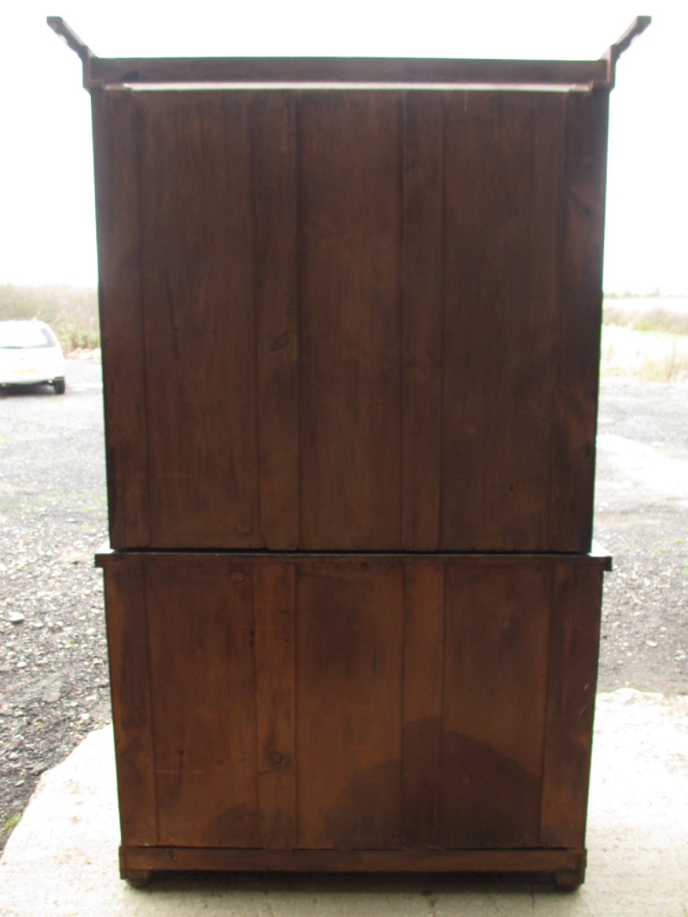 A two-piece Victorian mahogany bookcase featuring an upper section with two glazed doors and carved corbels over a lower cabinet with flame mahogany panelled doors. View XV